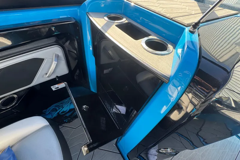 Slide: The Image of 2022 Yamaha Boats 255XD interior with blue accents and cup holders. - 30