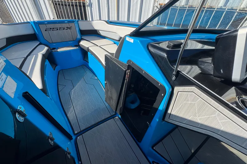 Slide: The Image of 2022 Yamaha Boats 255XD interior with blue and gray seating and modern dashboard. - 31