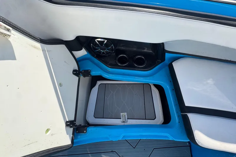 Slide: The Image of 2022 Yamaha Boats 255XD interior storage compartment with blue and white seating. - 38