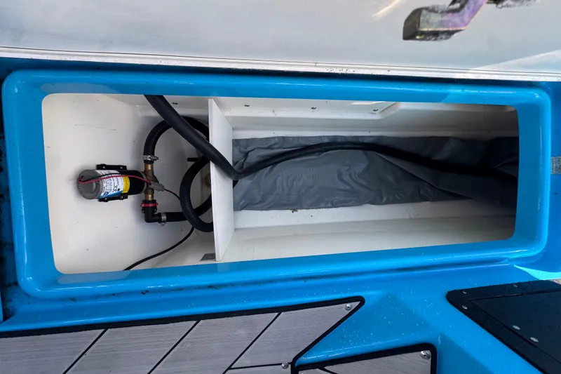 Slide: The Image of Open storage compartment in 2022 Yamaha Boats 255XD, featuring internal wiring and components. - 47