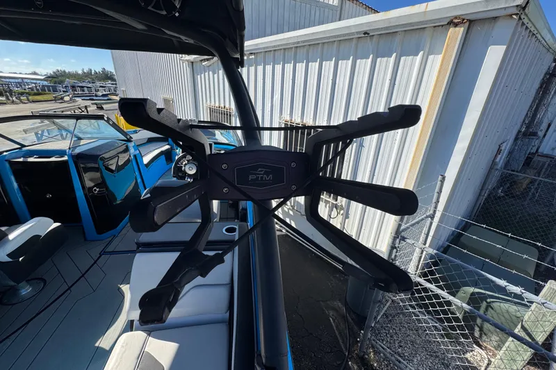 Slide: The Image of 2022 Yamaha Boats 255XD interior with PTM bracket, docked near a metal building. - 52