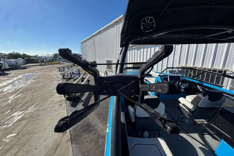 Slide: The Image of 2022 Yamaha Boats 255XD interior with seating and steering wheel, docked outdoors. - 54