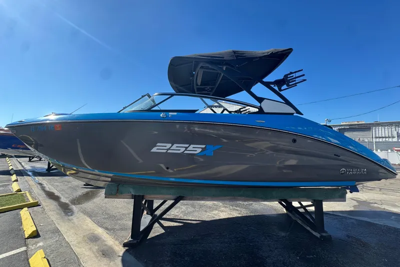 Slide: The Image of 2022 Yamaha Boats 255XD in blue and gray, displayed on a stand outdoors. - 6