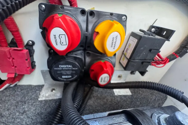 Slide: The Image of Electrical panel of a 2022 Yamaha Boats 255XD, featuring battery switches and wiring. - 65