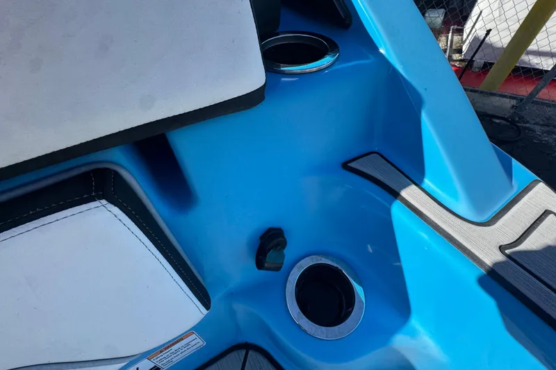 Slide: The Image of 2022 Yamaha Boats 255XD interior with blue accents and cup holders. - 77