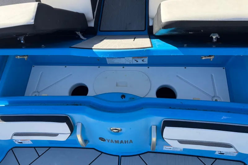 Slide: The Image of 2022 Yamaha Boats 255XD interior storage compartment with blue and white seating. - 84