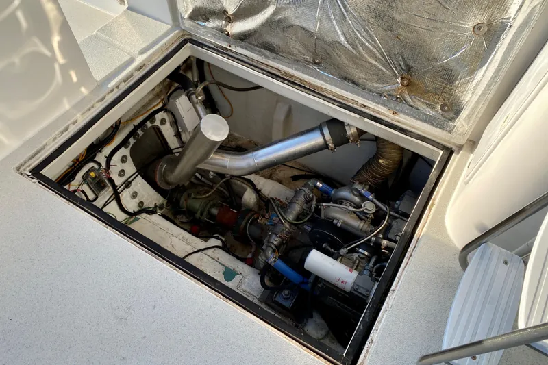 Slide: The Image of Engine compartment of a 2001 SportsCat 44 boat, showcasing mechanical components and wiring. - 100
