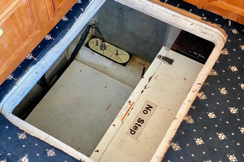 Slide: The Image of Hidden compartment in SportsCat 44, 2001 model, with "No Step" warning on carpeted floor. - 108