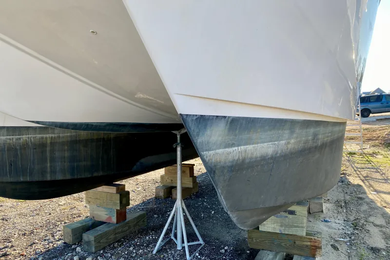 Slide: The Image of 2001 SportsCat 44 catamaran hulls on wooden blocks, dry docked for maintenance. - 11