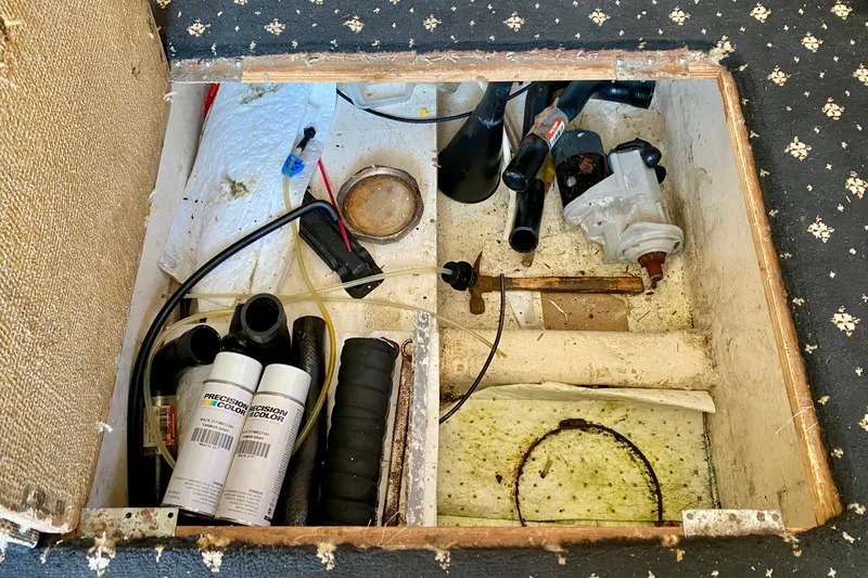 Slide: The Image of Open compartment in a 2001 SportsCat 44, showing various tools and maintenance supplies. - 114