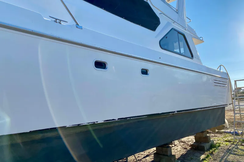 Slide: The Image of 2001 SportsCat 44 boat on dry dock, side view with clear blue sky. - 12