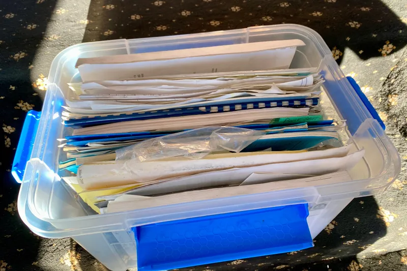 Slide: The Image of Clear plastic container filled with assorted documents and papers, illuminated by sunlight. - 124