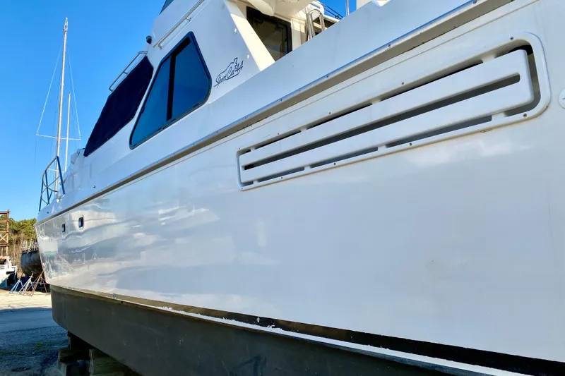 Slide: The Image of White SportsCat 44 boat from 2001, docked on land, side view. - 13