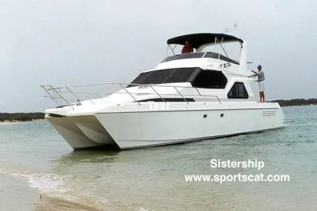 Slide: The Image of 2001 SportsCat 44 catamaran anchored near shore with two people on deck. - 131