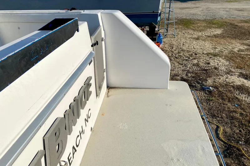 Slide: The Image of Rear deck of a 2001 SportsCat 44 boat, parked on sandy ground. - 24