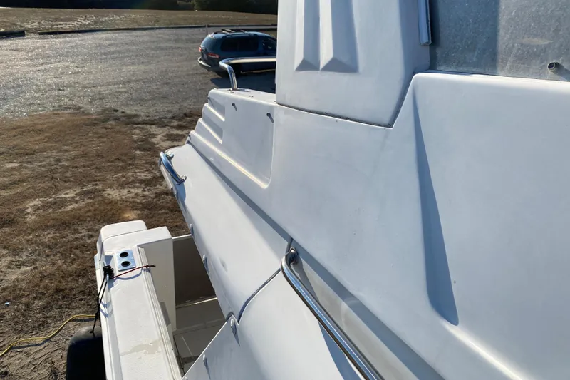 Slide: The Image of Side view of a 2001 SportsCat 44 boat on a trailer in a parking area. - 30