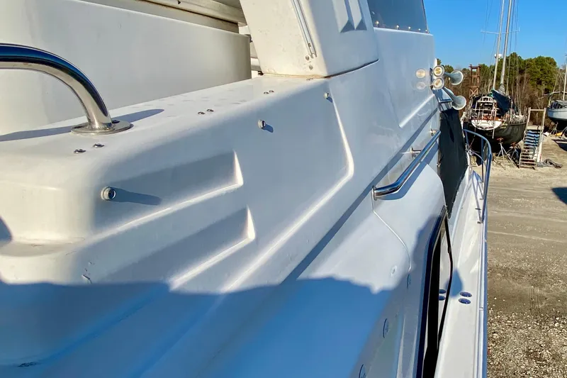Slide: The Image of Side view of a 2001 SportsCat 44 boat, showcasing sleek white design and metal railings. - 31