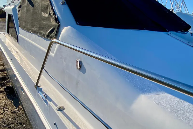 Slide: The Image of 2001 SportsCat 44 boat side view with metal railing and covered windows. - 34