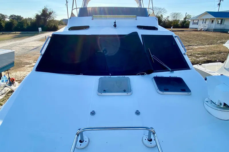 Slide: The Image of 2001 SportsCat 44 boat deck with hatches and windshield, parked outdoors. - 37