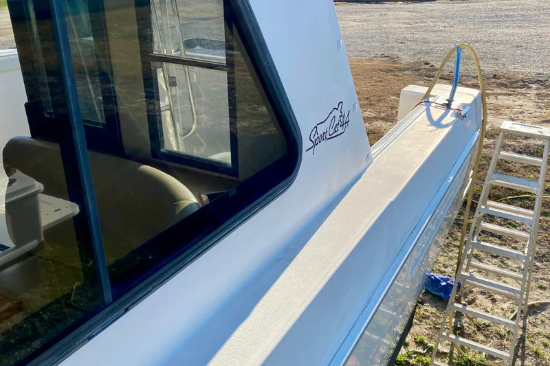 Slide: The Image of 2001 SportsCat 44 boat exterior with ladder, showcasing sleek design and window reflections. - 41