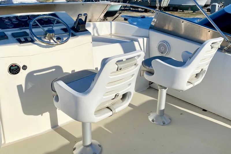Slide: The Image of 2001 SportsCat 44 boat cockpit with dual white captain chairs and steering console. - 43