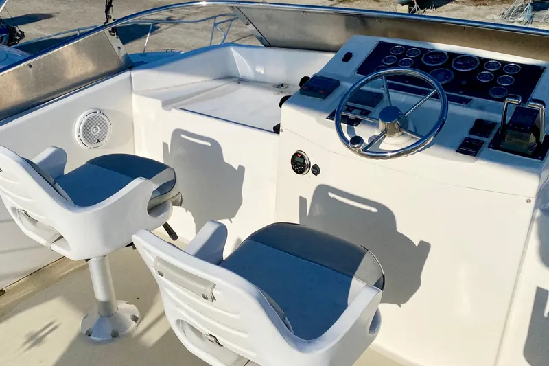 Slide: The Image of Two white seats and control panel on 2001 SportsCat 44 boat deck. - 45