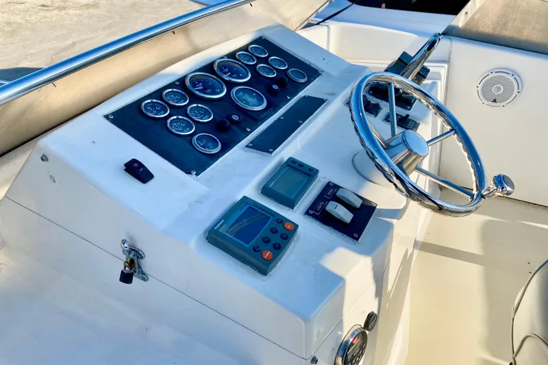 Slide: The Image of Control panel of a 2001 SportsCat 44 boat with gauges and steering wheel. - 48