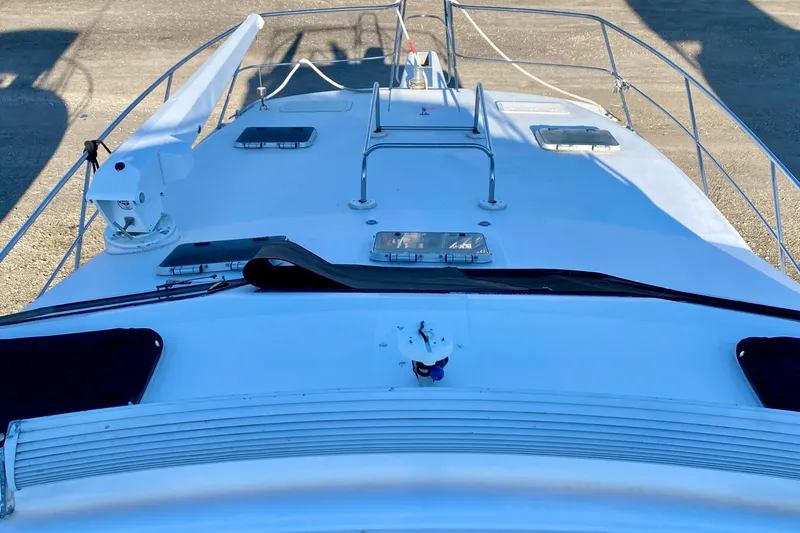 Slide: The Image of Front deck of a 2001 SportsCat 44 boat with railing and hatches. - 49