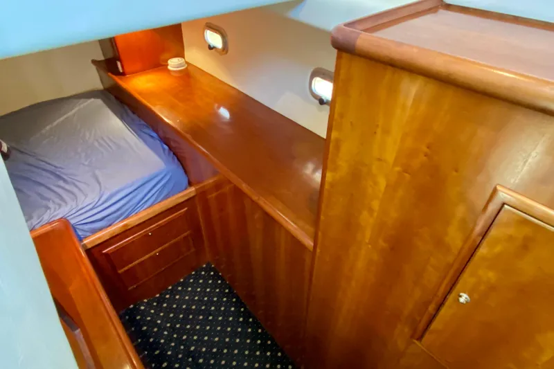 Slide: The Image of 2001 SportsCat 44 cabin interior with wooden finish and blue bedding. - 65