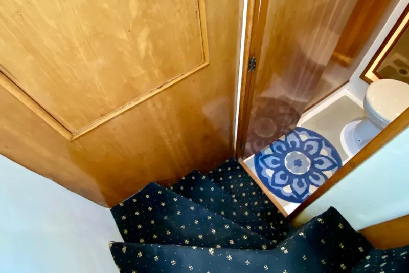 Slide: The Image of Staircase leading to a compact bathroom in a 2001 SportsCat 44 boat. - 68