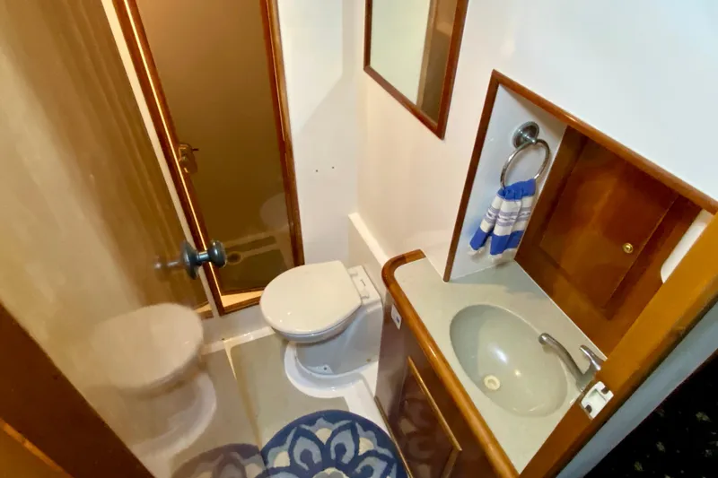 Slide: The Image of Compact bathroom in 2001 SportsCat 44 with sink, toilet, and wooden cabinetry. - 69