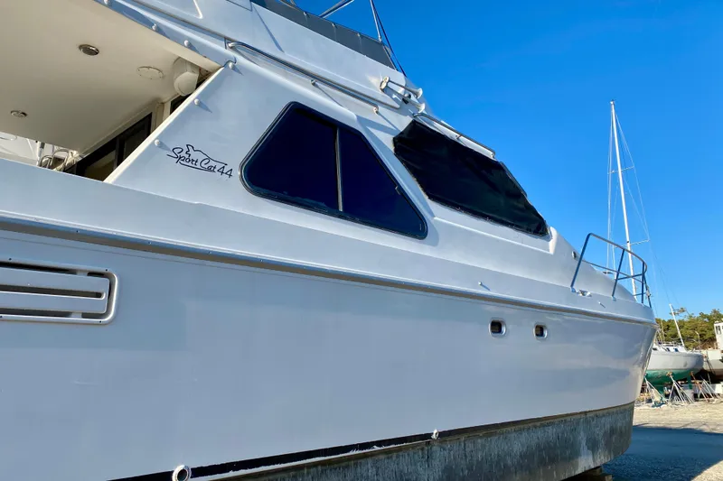 Slide: The Image of 2001 SportsCat 44 boat with sleek design, docked under clear blue sky. - 7
