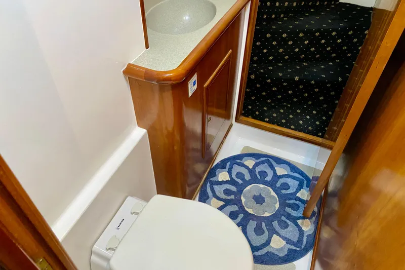 Slide: The Image of Compact bathroom in 2001 SportsCat 44 with wooden cabinetry and decorative blue rug. - 70