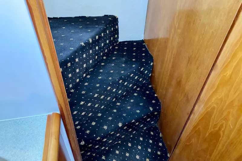Slide: The Image of Carpeted stairs in a 2001 SportsCat 44 boat interior. - 71