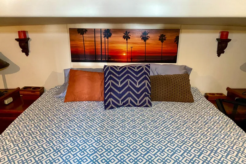 Slide: The Image of Cozy bedroom with patterned bedding, decorative pillows, and sunset artwork, inside a 2001 SportsCat 44. - 75