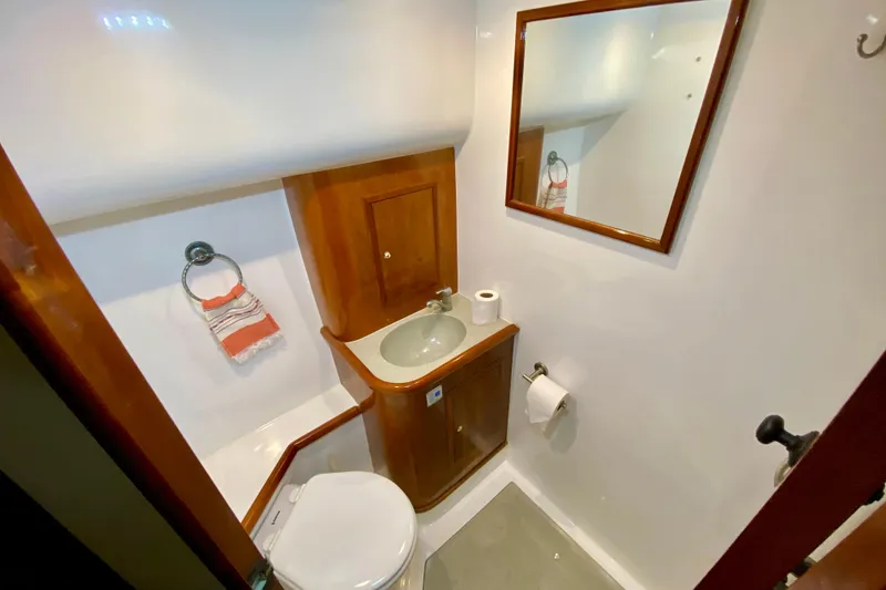 Slide: The Image of Compact bathroom in 2001 SportsCat 44 boat with wooden cabinetry and mirror. - 78
