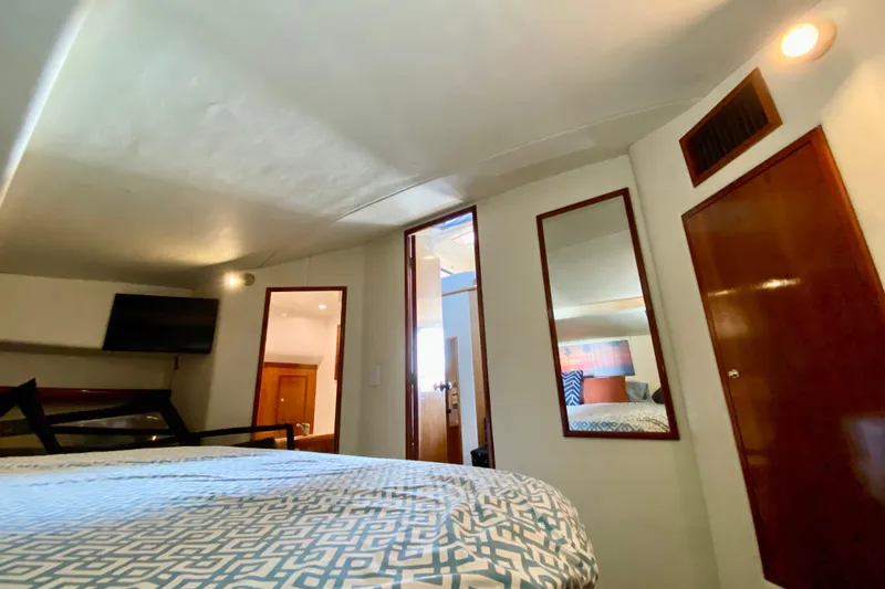 Slide: The Image of Cozy bedroom interior with mirrors, patterned bedding, and wall-mounted TV in a 2001 SportsCat 44. - 82