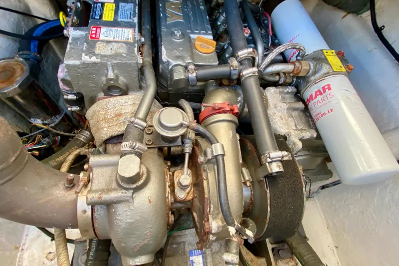 Slide: The Image of Engine compartment of a 2001 SportsCat 44, featuring mechanical components and a Yanmar filter. - 96