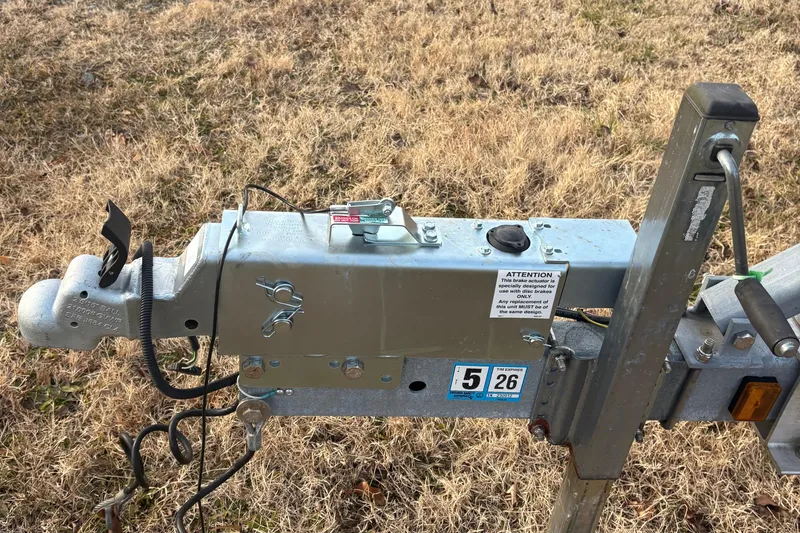 Slide: The Image of Trailer hitch mechanism on grass, part of a 2014 Mako 234 Center Console boat. - 4