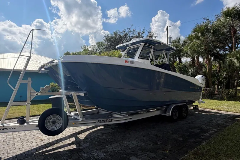 The Image of 2025 Twin Vee 260 GFX2 CC boat on trailer, parked outdoors under a sunny sky. - 0