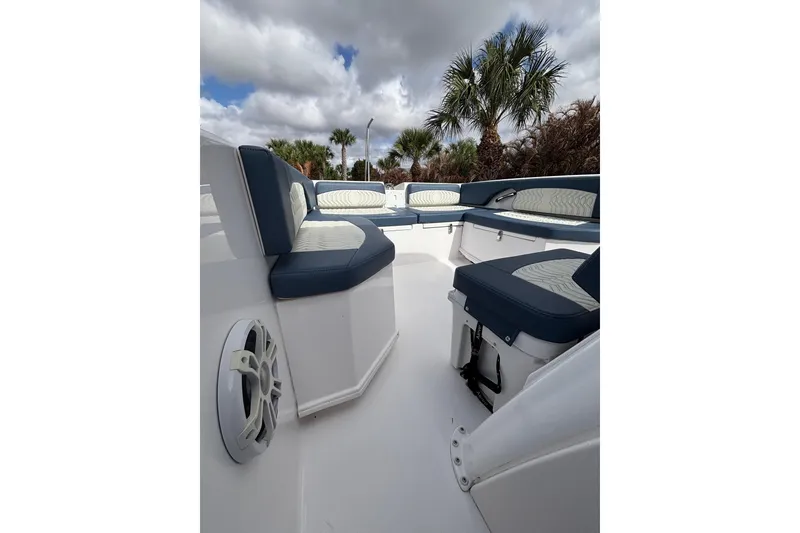 Slide: The Image of 2025 Twin Vee 260 GFX2 CC boat interior with cushioned seating and speaker, under cloudy sky. - 13