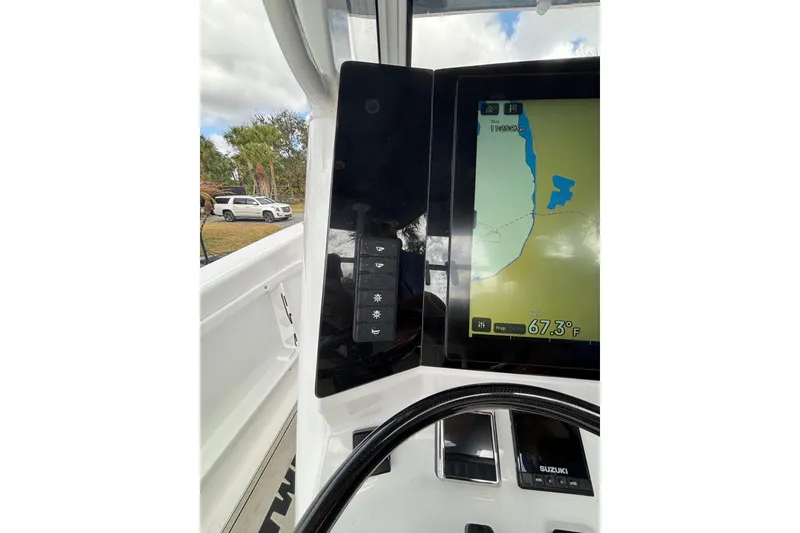 Slide: The Image of 2025 Twin Vee 260 GFX2 CC boat dashboard with navigation display and controls. - 16