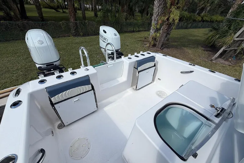 Slide: The Image of 2025 Twin Vee 260 GFX2 CC boat interior with Suzuki engines, featuring storage and seating. - 2