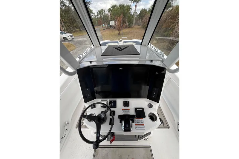 Slide: The Image of 2025 Twin Vee 260 GFX2 CC boat console with steering wheel and navigation controls. - 26