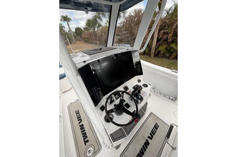 Slide: The Image of 2025 Twin Vee 260 GFX2 CC boat cockpit with steering wheel and control panel. - 27