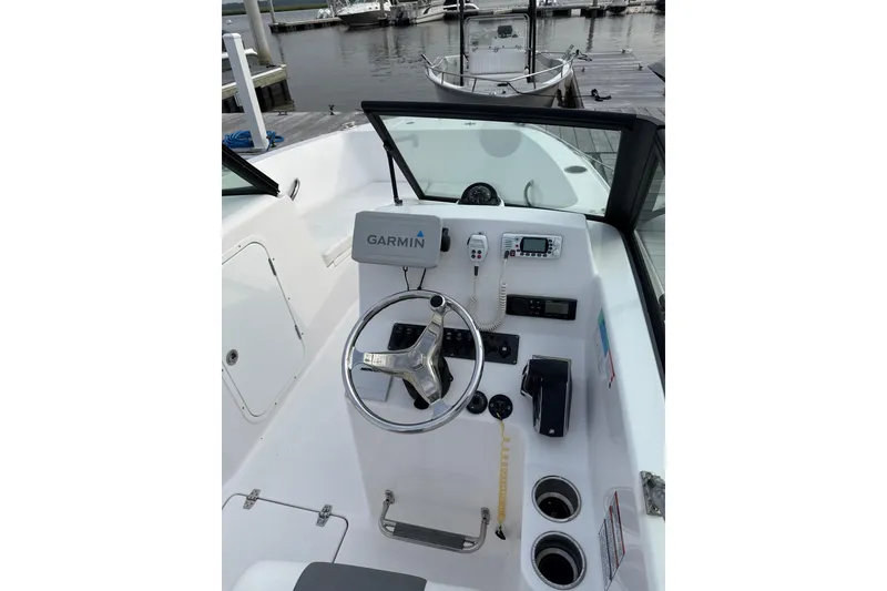 Slide: The Image of 2024 Aquasport 2200 Center Console boat with Garmin navigation at dock. - 5