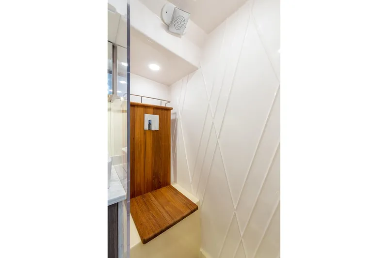 Slide: The Image of Manufacturer Provided Image: 2022 Regal 38 SAV boat shower with wooden seat and modern fixtures. - 13