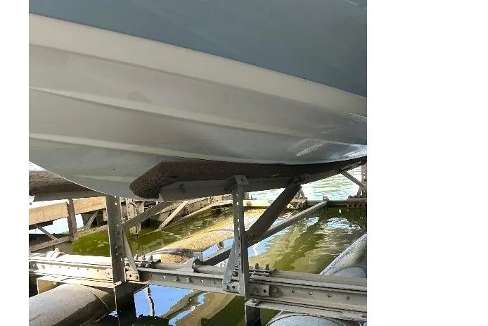 Slide: The Image of 2023 Skeeter SX210 boat hull on a lift over water. - 11