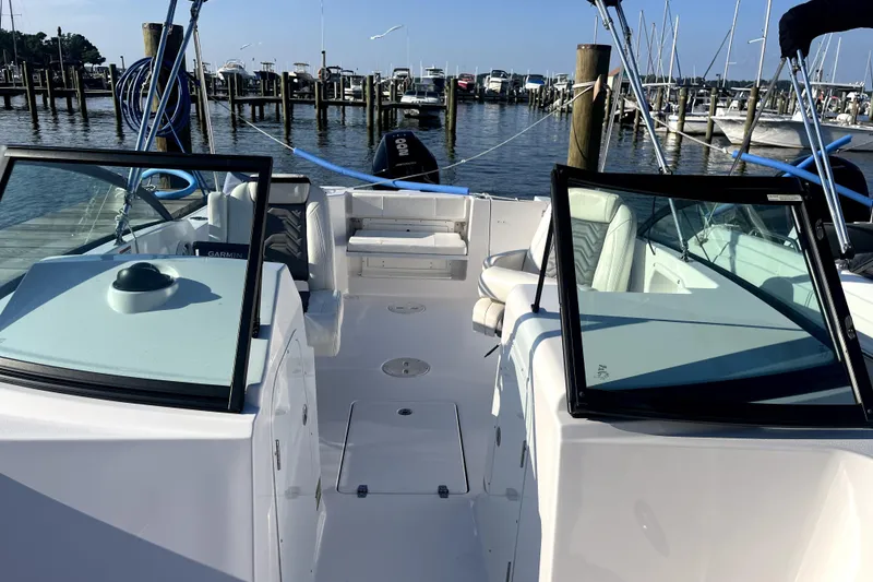 Slide: The Image of 2024 Aquasport 2200 Dual Console boat docked at marina, featuring spacious seating. - 4