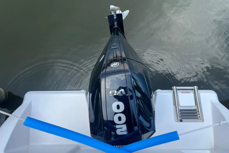 Slide: The Image of 2024 Aquasport 2200 Dual Console boat with powerful outboard motor and swim ladder. - 9